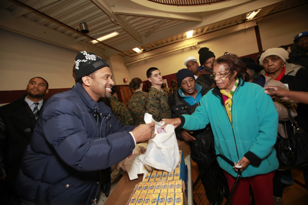 Mike giving Turkey Day items to Detroit families in need .
